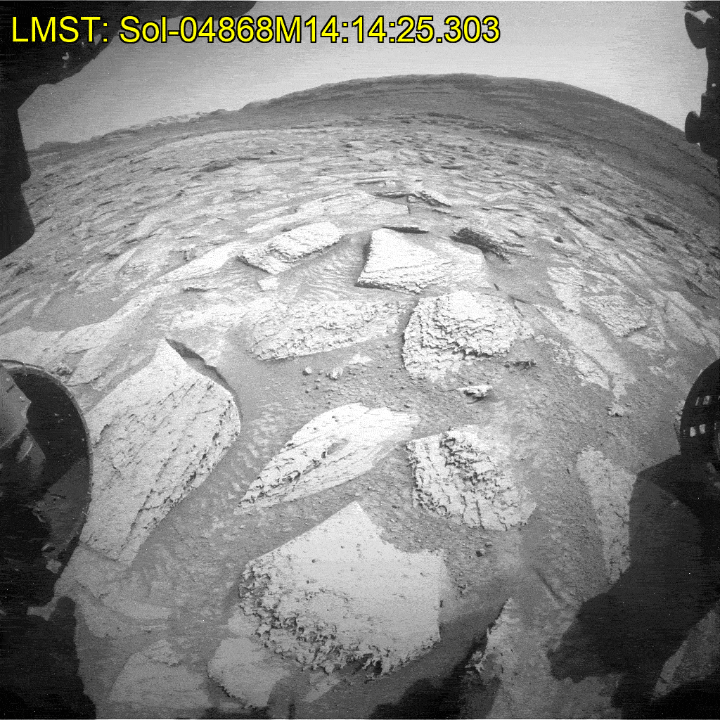 The Curiosity rover's drill shaking a rock loose, which then drops to the Martian surface.